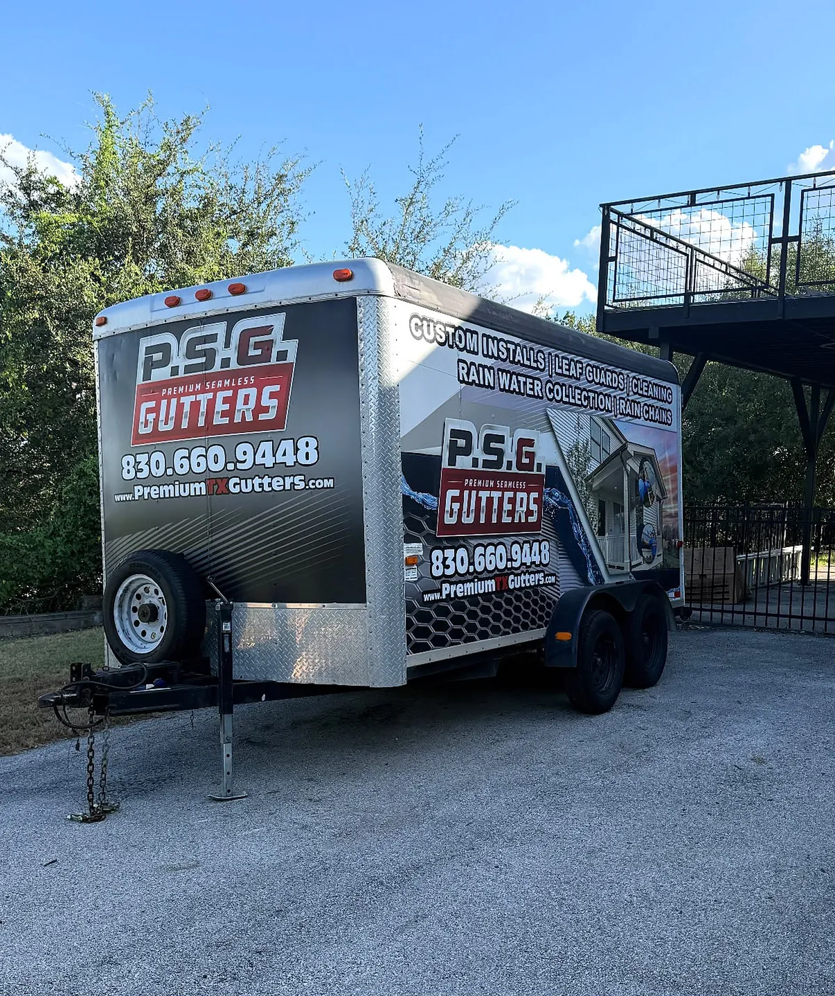 The PSG gutter trailer parked on a driveway, wrapped in the company's red and black graphics